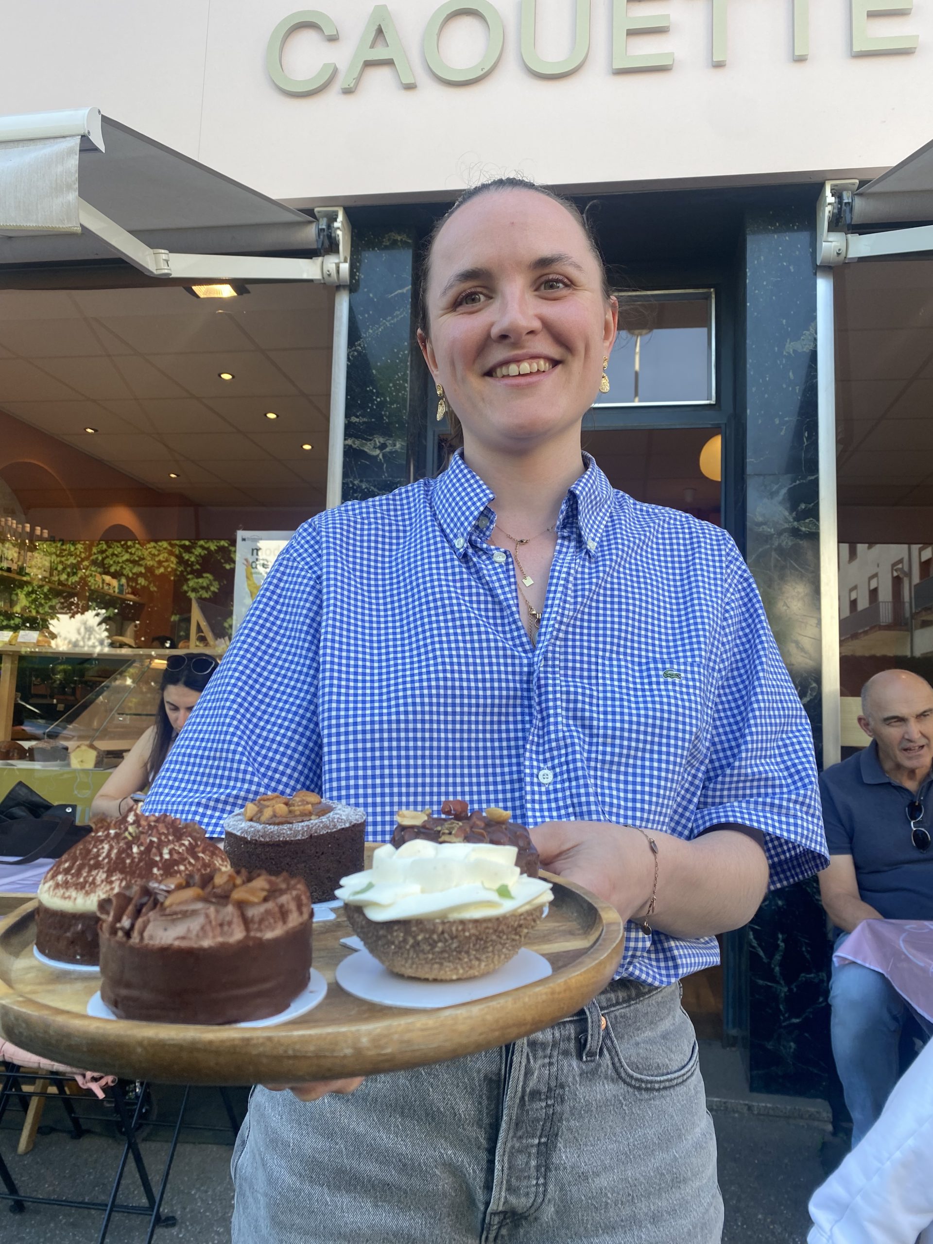 Axelle sourit en présentant ses pâtisseries